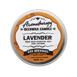 May include: A silver tin with an orange label that reads "Aromatherapy Beeswax Candle Lavender Made with Essential Oils 100% Natural Zax Beeswax 100% Pure & Natural Beeswax Candles Veteran Owned and Operated Net Wt. 4 oz."