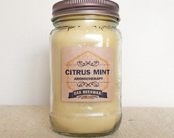 May include: A glass jar candle with a brown label that reads "Citrus Mint Aromatherapy" and "Zax Beeswax 100% Pure & Natural Beeswax Candles".