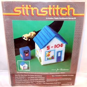 May include: A plastic needlepoint canvas kit titled "Sit 'n Stitch." The kit features a miniature house with a blue roof and the text "5-10¢," a blue mailbox, and a yellow car. The kit includes yarn and a needle.