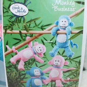 May include: A white ceramic mug with a black handle and the text "But First, Coffee" in a bold, black font. The mug is set against a blurred background, suggesting a cozy setting.