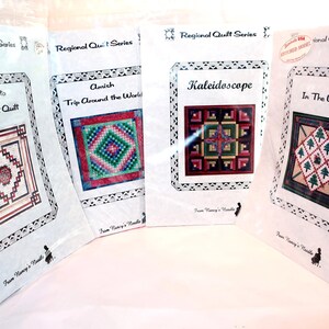May include: Four Regional Quilt Series pattern booklets from Nancy's Needle, each in a clear plastic sleeve. Titles include Terracotta Celtic Knot Quilt, Amish Trip Around the World, Kaleidoscope, and In The Woods, featuring colorful quilt illustrations.