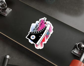 Puede incluir: Una ilustración en blanco y negro de una zapatilla de caña alta con el texto "Él era un niño, ella era una niña" sobre un fondo de acuarela rosa, azul y morado.