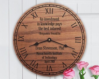 May include: A wooden clock with Roman numeral markings and a quote by Benjamin Franklin: "An investment in knowledge pays the best interest." The clock also includes the text "Evan Stevenson, Phd, Massachusetts Institute of Technology, April 2019."