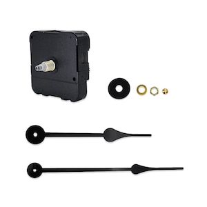 May include: A black clock movement kit with various components. The kit includes a square-shaped movement, a black washer, brass and gold-colored nuts, and two black clock hands. The hands have a circular end and a pointed, decorative design.