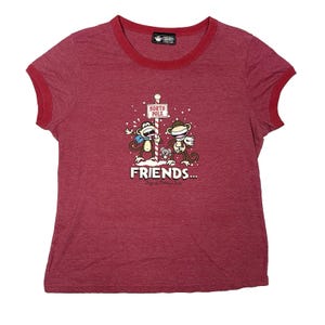 May include: Red ringer tee shirt with a graphic of two cartoon monkeys at the North Pole. The monkeys are wearing scarves and holding a sign that says "North Pole". The word "FRIENDS..." is printed below the monkeys.