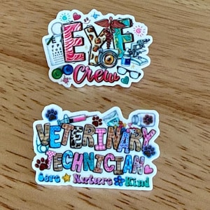 May include: Two colorful stickers on a wooden surface. The top sticker reads "EYE Crew" with eye-related graphics. The bottom sticker says "VETERINARY TECHNICIAN" with paw prints and medical tools. The text "Care, Nurture & Kind" is also included.