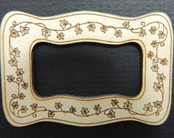 May include: A wooden frame with a cutout in the center. The frame is decorated with a vine pattern of leaves.
