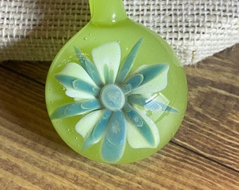 Teal Spider Glass Pendant with White Petals and Pale Green Background