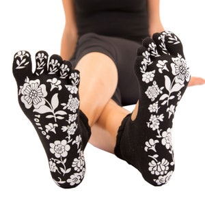 May include: A pair of black toe socks with a white floral pattern. The socks are made of a soft, breathable fabric and are designed to provide comfort and support.