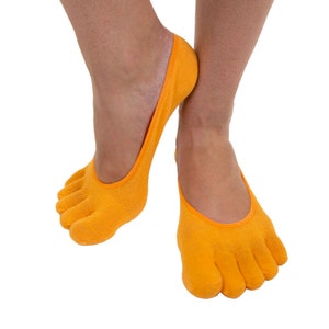 Puede incluir: Un par de calcetines de dedos de color naranja con un diseño sin costuras. Los calcetines están hechos de un material suave y elástico y son perfectos para usar con zapatos de corte bajo.