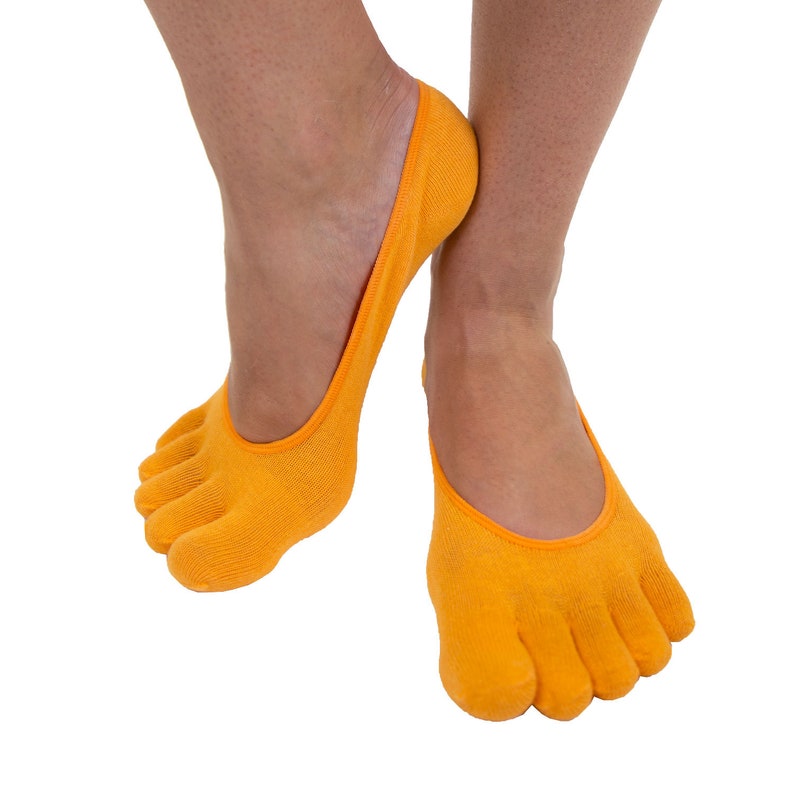 Pu&ograve; includere: Un paio di calzini a dita di colore arancione con un design senza cuciture. I calzini sono realizzati in un materiale morbido ed elastico e sono perfetti da indossare con scarpe basse.
