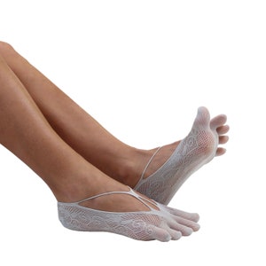 May include: White lace toe socks with a criss-cross strap design. The socks are made of a delicate, breathable fabric and are perfect for yoga, pilates, or dance.