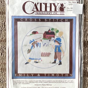 May include: Cross stitch pattern featuring two children, Emily and Timothy, standing in front of a red barn with a white fence. The pattern includes a blue sky, green grass, and a white sheep. The pattern is titled "Emily & Timothy" and is from Cathy Needlecraft, Inc.