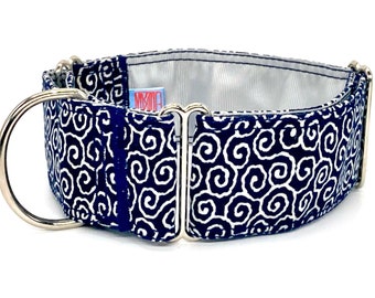 Puede incluir: Un collar para perros con estampado azul marino y blanco, con un anillo en D y un cierre de metal plateado. El collar presenta un diseño de remolinos repetidos. El forro interior es de tela gris claro. Una pequeña etiqueta con texto es visible.