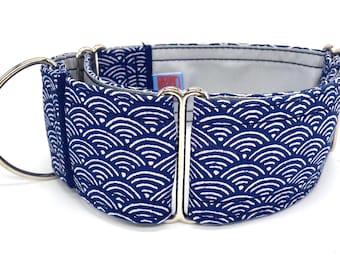 Puede incluir: Un collar para perros azul marino con un estampado de olas blancas. El collar tiene una anilla en D y herrajes de metal plateado. El interior es de tela gris claro. Este collar está diseñado para perros.