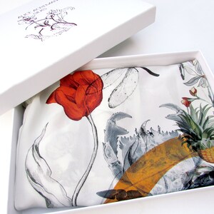 May include: A white box with a silk scarf inside. The scarf features a large red tulip, gray crab claws, and a pineapple design. The box lid has the text "ALICE AGRILAN SILKS" and a floral illustration.