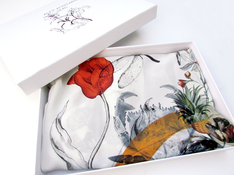May include: A white box with a silk scarf inside. The scarf features a large red tulip, gray crab claws, and a pineapple design. The box lid has the text "ALICE AGRILAN SILKS" and a floral illustration.