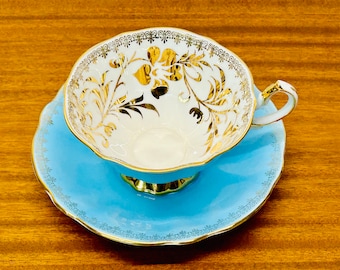 Vintage Queen Anne theekop en schotel: blauw en goud bloemenbotten porselein