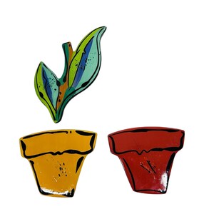 May include: Three ceramic painted planters, one with a green and blue leaf design and two with red and yellow rimmed designs.