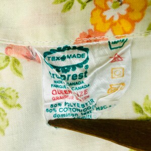 Puede incluir: Una etiqueta blanca con texto verde y rojo que dice "Tex Made TruRest Made Canada Fabrique Canada Queen Size Grandeur Queen 50% Polyester 50% Algod&oacute;n/Coton Text H3C Dominion"