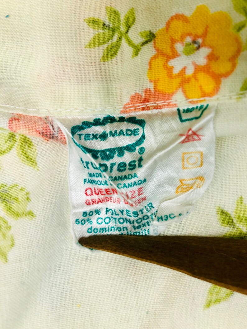Puede incluir: Una etiqueta blanca con texto verde y rojo que dice "Tex Made TruRest Made Canada Fabrique Canada Queen Size Grandeur Queen 50% Polyester 50% Algod&oacute;n/Coton Text H3C Dominion"