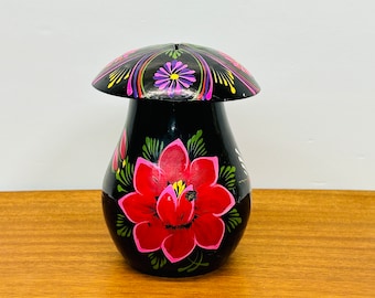 May include: Black ceramic jar with a mushroom-shaped lid. The jar is hand-painted with colorful flowers and floral designs.