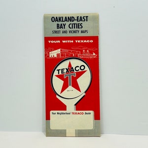 May include: A vintage red and white Texaco map for Oakland-East Bay Cities. The map features a Texaco star logo and the text "Tour with Texaco".