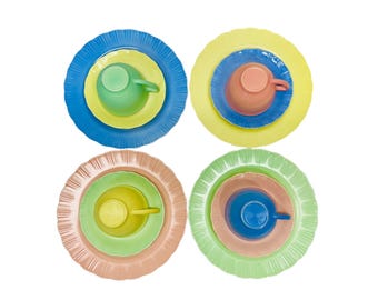 May include: Four sets of colorful dishware, each with a unique arrangement. Each set includes a large plate, a smaller plate, and a cup. The color schemes include blue, yellow, green, and peach, creating a vibrant and playful aesthetic.