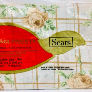 May include: A white and brown floral sheet set with a grid pattern. The packaging says "Perma-Prest" and "Never Needs Ironing" and is labeled "double size - flat 205 cm X 240 cm plat - lit double". The packaging also says "Sears" and "Made in Canada for Simpsons-Sears".