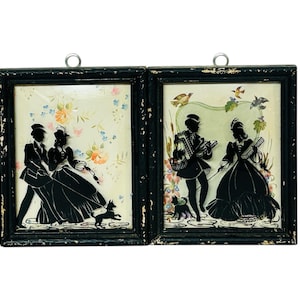 May include: Two framed silhouette pictures with black silhouettes of couples on a white background. The frames are black wood with a distressed look.