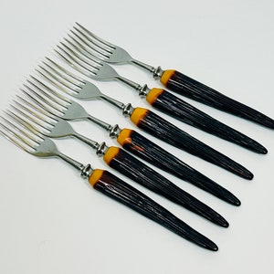 Puede incluir: Juego de seis tenedores de plata con mangos rayados en negro y amarillo.