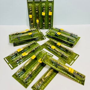 May include: A collection of 13 gold-toned cabinet door pulls in various styles and sizes, packaged in clear plastic with green and white labels. The labels read "Windsor Hardware".