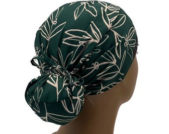 May include: A green and white patterned scrub hat with a bun cover. The hat is tied at the back of the head.