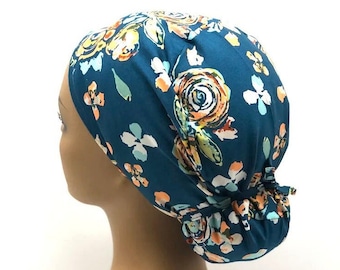 Peut inclure: Un bonnet de scrub chirurgical bleu sarcelle avec un imprimé floral composé de fleurs orange, jaunes, blanches et vertes. Le bonnet a un dos plissé et se noue à l'arrière.