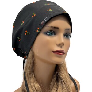 May include: Black scrub hat with a cherry print and the text "MedScrub Studio" on the side. The hat has a tie at the back.