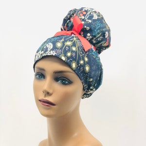 May include: A blue and white floral print scrub hat with a red ribbon tied in a bun on top.