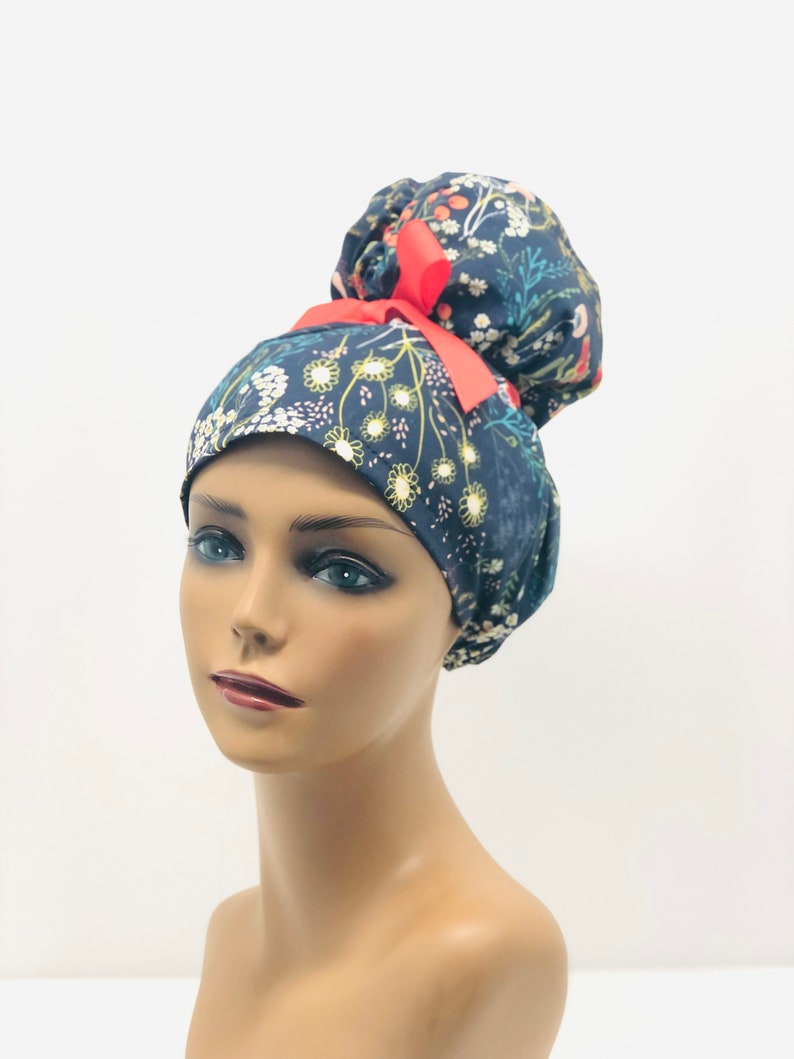 May include: A blue and white floral print scrub hat with a red ribbon tied in a bun on top.