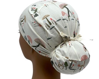 May include: A white scrub cap with a mushroom print. The cap has a tie at the back to adjust the fit.