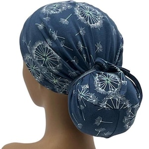 Pode incluir: Uma touca cir&uacute;rgica azul marinho com um padr&atilde;o de dente-de-le&atilde;o branco. A touca &eacute; amarrada em um coque na parte de tr&aacute;s, com uma fita de tecido combinando. Esta touca &eacute; projetada para cobrir o cabelo e &eacute; adequada para ambientes m&eacute;dicos ou profissionais.