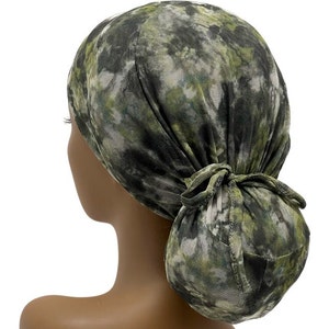 May include: A green and white tie-dye scrub hat with a ponytail opening. The hat is made of a soft, breathable fabric and is perfect for nurses, doctors, and other healthcare professionals.