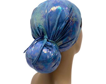 May include: A blue and iridescent surgical scrub hat with a ponytail hole. The hat is tied at the back with a matching fabric tie.