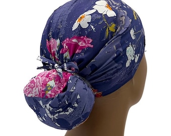 Puede incluir: Un gorro de quirófano de color azul y rosa con estampado floral y un cubre-moño. El gorro tiene un lazo en la parte posterior para sujetarlo en su lugar.