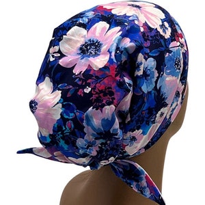 May include: A blue and pink floral print scrub hat with a tie at the back.