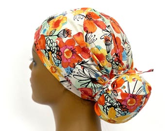Bonnet de bloc opératoire Ava à queue de cheval, imprimé floral orange et jaune, fait main en coton.