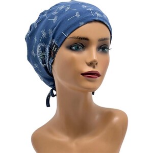 Pode incluir: Uma touca cir&uacute;rgica azul com um padr&atilde;o de dente-de-le&atilde;o branco. A touca &eacute; amarrada na parte de tr&aacute;s e tem uma pequena etiqueta na lateral. A touca foi projetada para cobrir o cabelo.