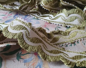 May include: Green and white trim with a scalloped edge. The trim has a woven design with a repeating pattern.
