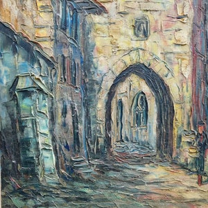 May include: A painting depicting a narrow, cobbled street in a European city. The street is flanked by tall, stone buildings, and there is a large archway at the end of the street. The painting is executed in a painterly style, with thick brushstrokes and a warm colour palette.