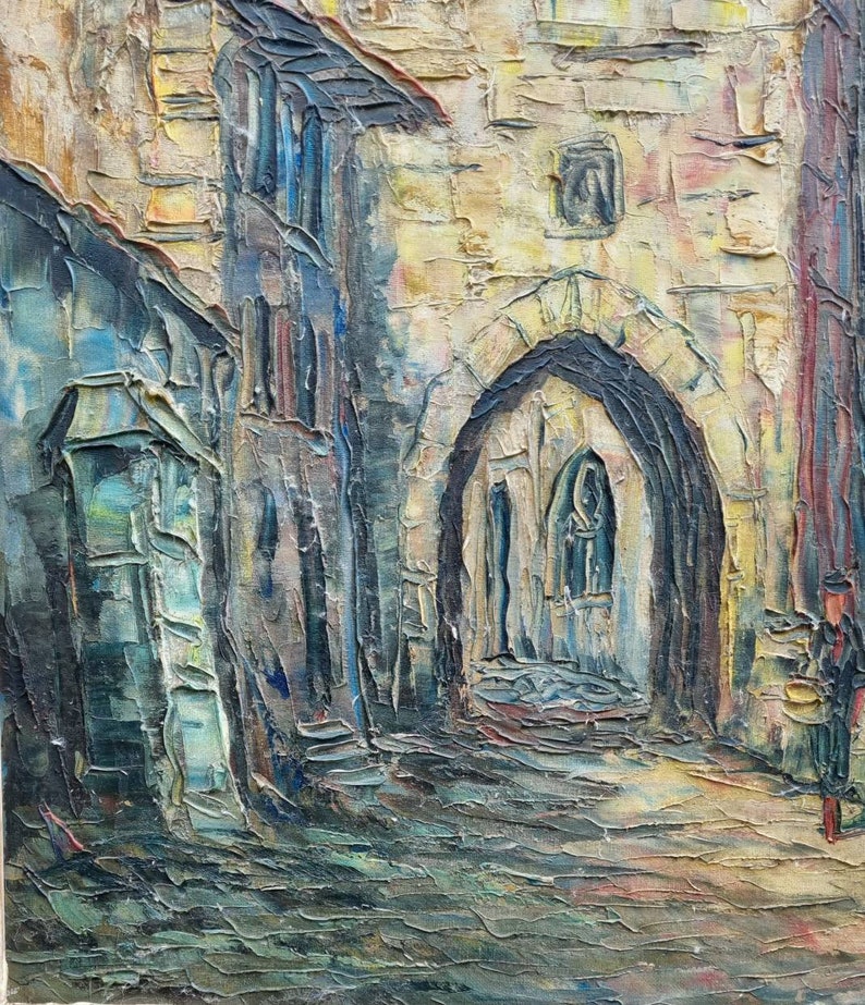 May include: A painting depicting a narrow, cobbled street in a European city. The street is flanked by tall, stone buildings, and there is a large archway at the end of the street. The painting is executed in a painterly style, with thick brushstrokes and a warm colour palette.