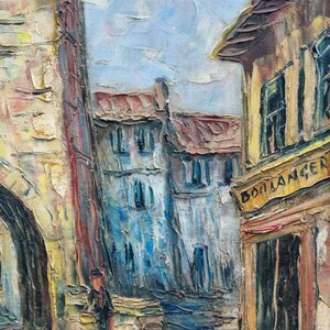 May include: A painting depicting a European street scene with a tall stone tower, a building with a sign that reads "BOULANGER", and a person walking in the street.