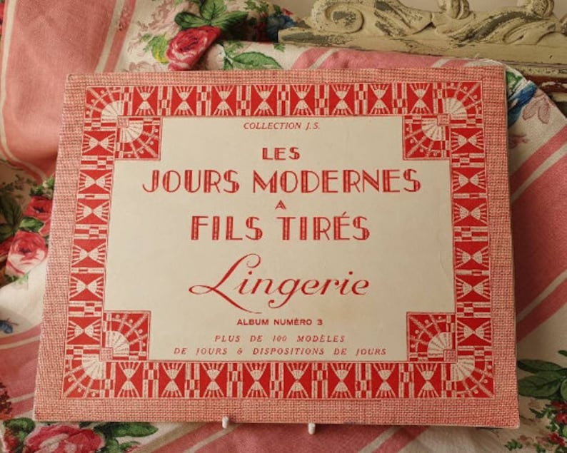 Peut inclure: Un livre vintage rouge et blanc intitul&eacute; "Les Jours Modernes a Fils Tires Lingerie Album Numero 3" avec le texte "Plus de 100 Modeles de Jours & Dispositions de Jours".